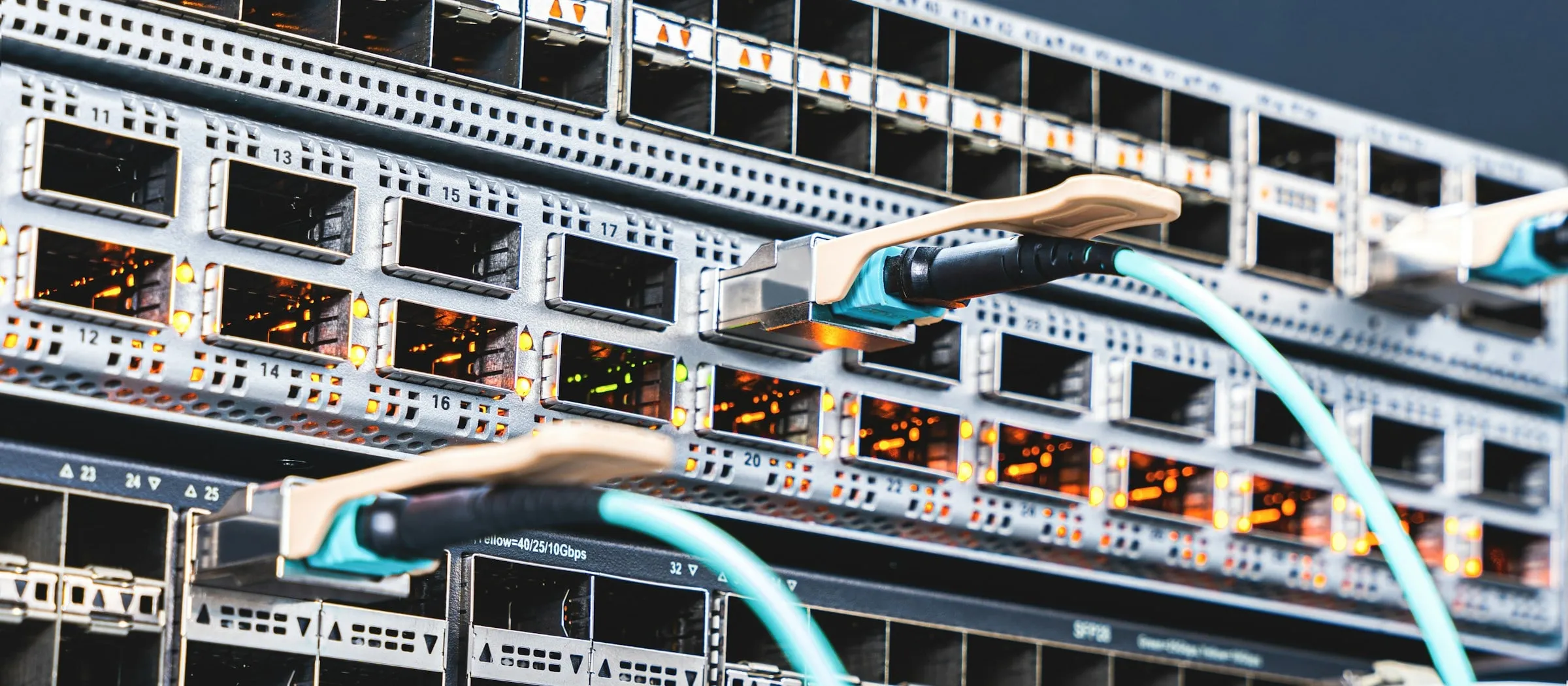 Teal patch cables plugged into the numbered ports of a network switch.